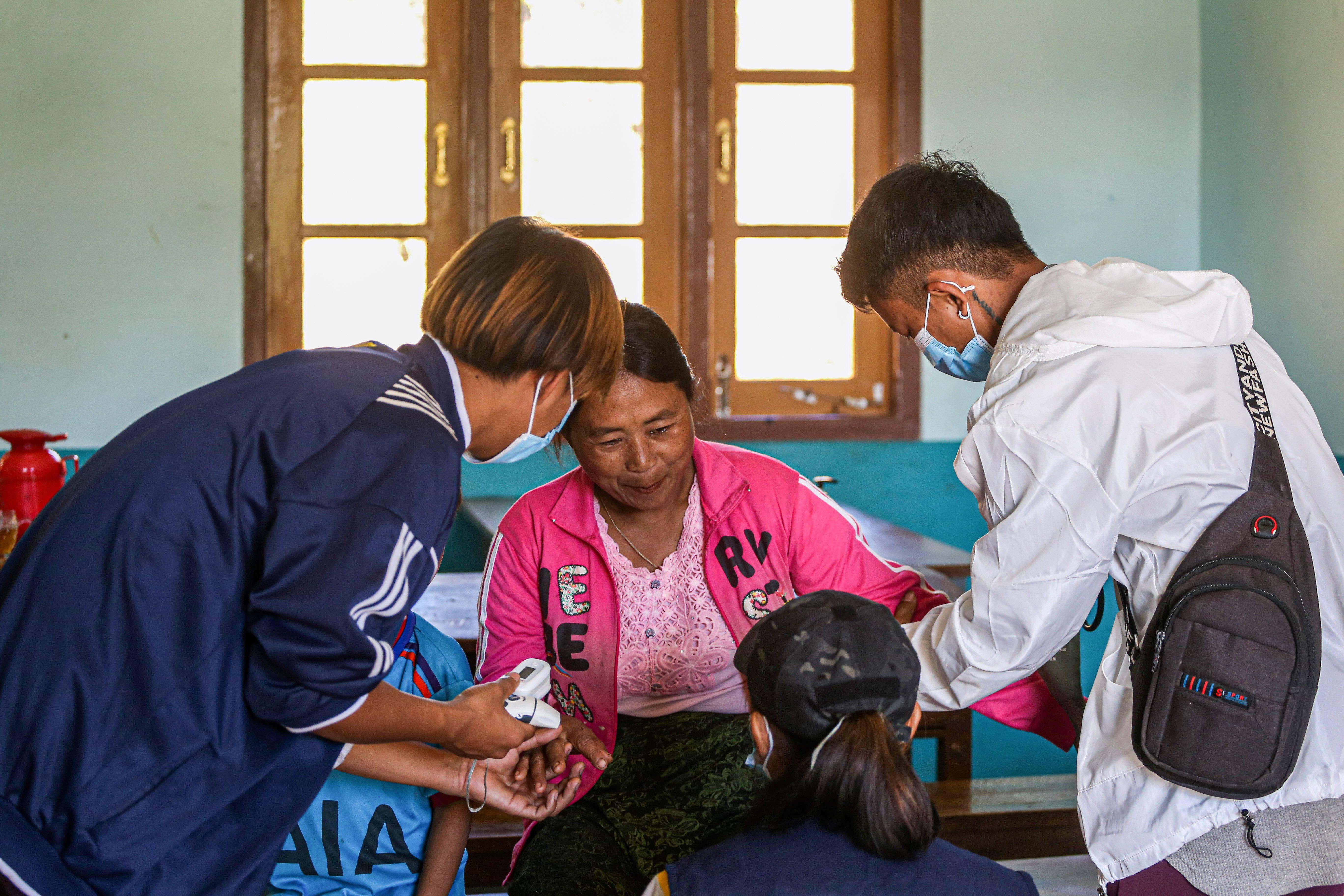 : Medical volunteers from ‘Nway Oo Sayy aid’ take care of a Karen refugee in an IDP camp in Kayah State, Myanmar.